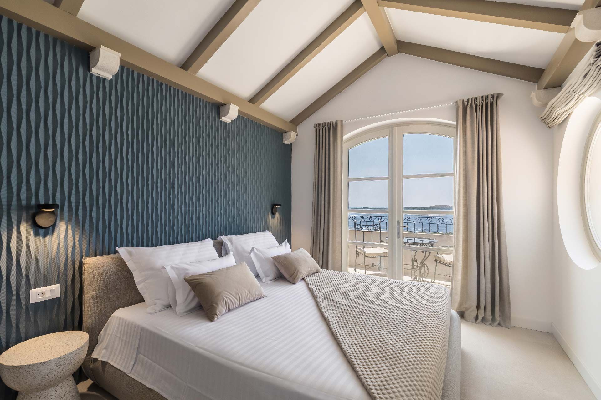 Sea-view bedroom with arched windows at Villa del Mar